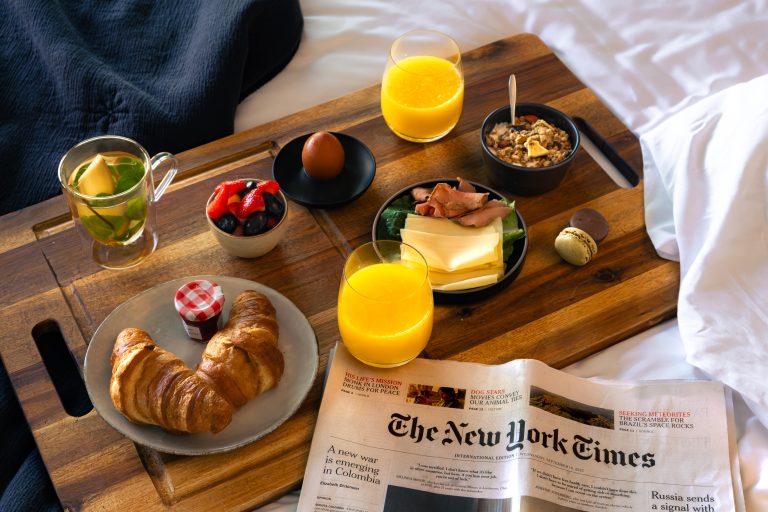 Uitgebreid ontbijt op bed met krant