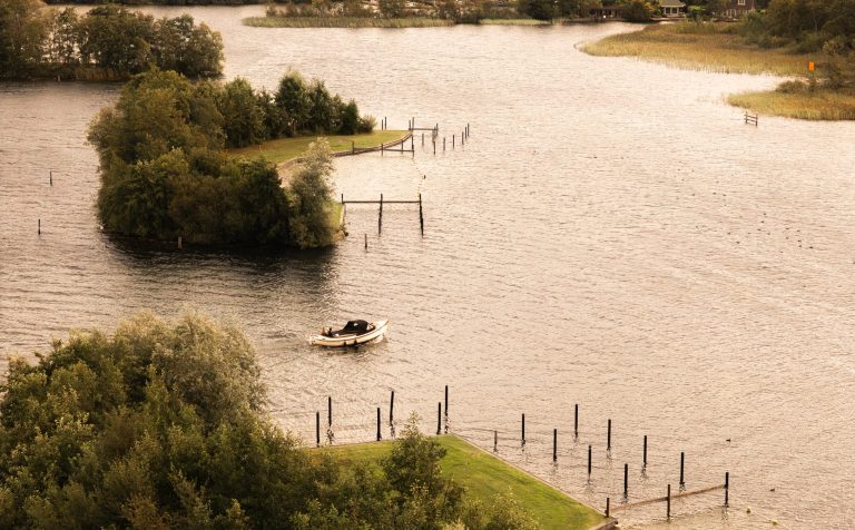 Sloep varen op het water midden in de natuur