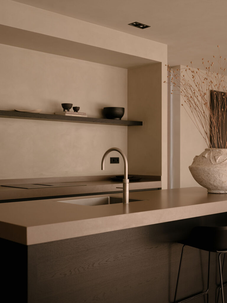 Minimalistische offene Küche mit Kochinsel, natürlichen Materialien und ruhigen Erdtönen für eine stilvolle, luxuriöse und nachhaltige Ausstrahlung