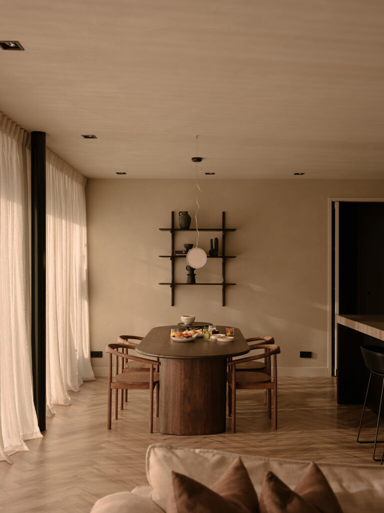 Stilvolle Essecke mit Holztisch, Designerstühlen, Leinenvorhängen und dezenter Dekoration in einer ruhigen und gemütlichen Villa